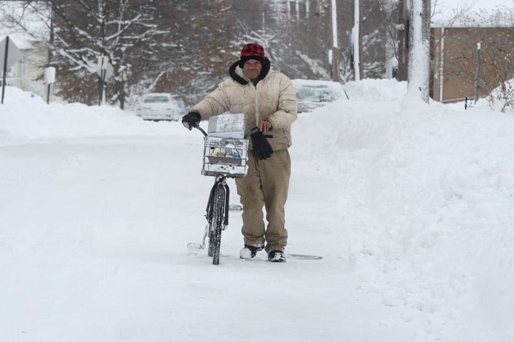 Logan Rogers schiebt in Erie, Pennsylvania, USA, sein Fahrrad durch den Schnee.