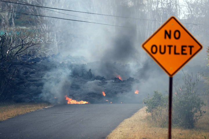 Hier bahnt sich flüssige Lava ihren Weg mitten über eine Straße. Besonders von den gefährlichen Strömen betroffen ist Hawaiis Big Island.