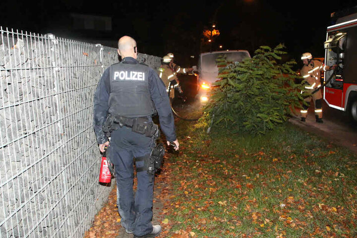 Ein Polizist hält einen Feuerlöscher in der Hand.