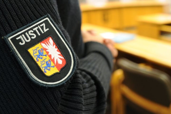 Ein schleswig-holsteinischer Justizbeamter steht im Landgericht im Sitzungssaal.