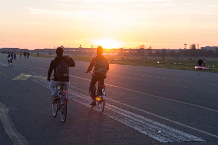 Bei untergehender Sonne und blauem Himmel zieht es immer wieder Radfahrer auf das Tempelhofer Feld.