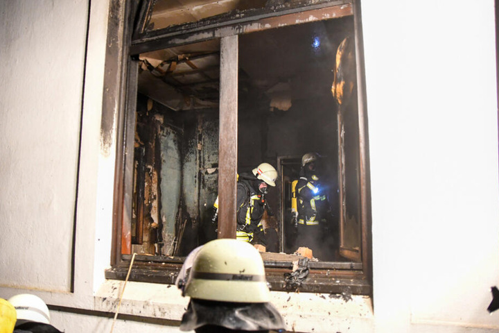 Einsatzkräfte durchsuchen das Zimmer nach Brandherden.