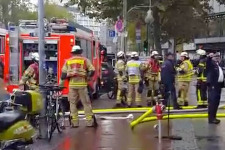 Feuerwehrmänner sind vor dem Europa-Center und tragen Ausrüstung ins Gebäude.