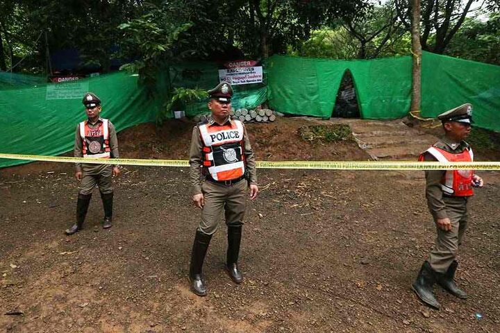 Polizisten bewachen den abgesperrten Zugang zu der Höhle.
