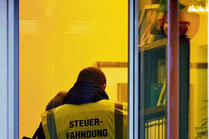 Ein Steuerfahnder, fotografiert bei einer Hausdurchsuchung.
