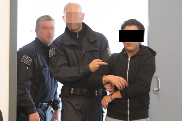 Nasser A. (25) wird von Sicherheitskräften in den Saal des Oberlandesgerichtes geführt.