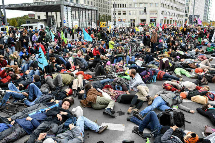 Aktivisten demonstrieren am Potsdamer Platz und legen sich dabei auf den Boden.