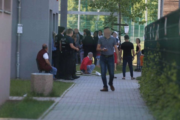 Polizisten stehen vor dem Eingang des Hauses, aus dem das Mädchen am Sonntag fünf Stockwerke tief in den Tod fiel.