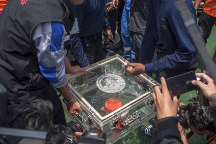 Mitglieder des Nationalen Verkehrssicherheitskomitees heben eine Box mit dem Flugdatenschreiber von der abgestürzten Lion-Air-Maschine an Bord eines Rettungsschiffes.