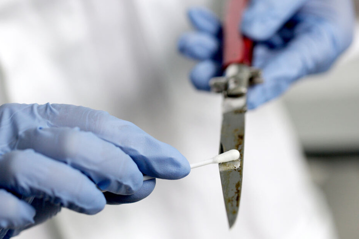 Eine Labormitarbeiterin nimmt im Amtssitz des Landeskriminalamts Nordrhein-Westfalen in Düsseldorf (Nordrhein-Westfalen) eine DNA-Probe von einem Messer.