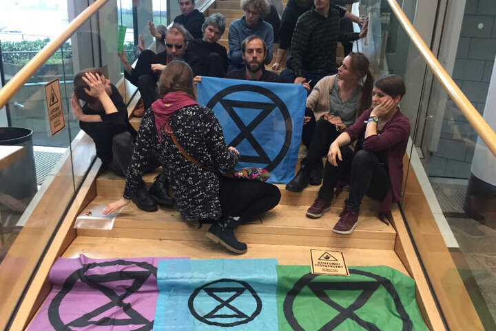 Klimaaktivisten sitzen auf einer Treppe im nordrhein-westfälischen Landtag.
