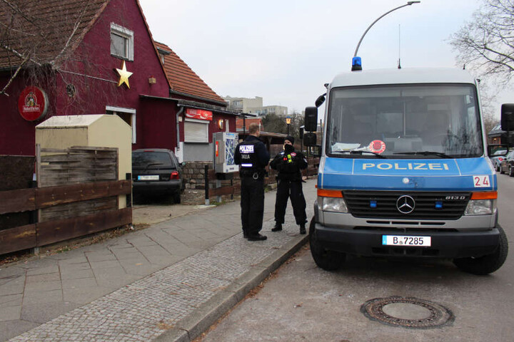 Ein Polizeiwagen steht vor einem durchsuchten Objekt in Berlin Spandau.