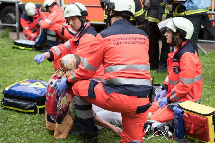 Rettungskräfte versorgen Bewohner vor dem Haus.
