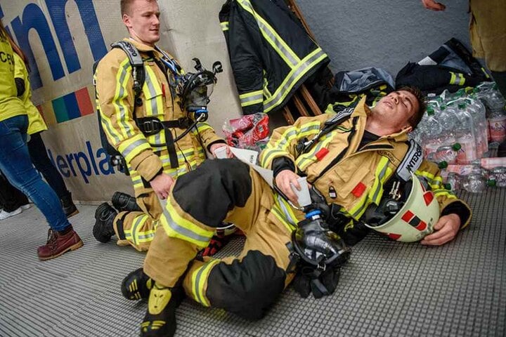 Geschafft aber vollkommen fertig. Zwei Feuerwehrmänner ruhen sich aus, nachdem sie im 39. Stock angekommen sind.