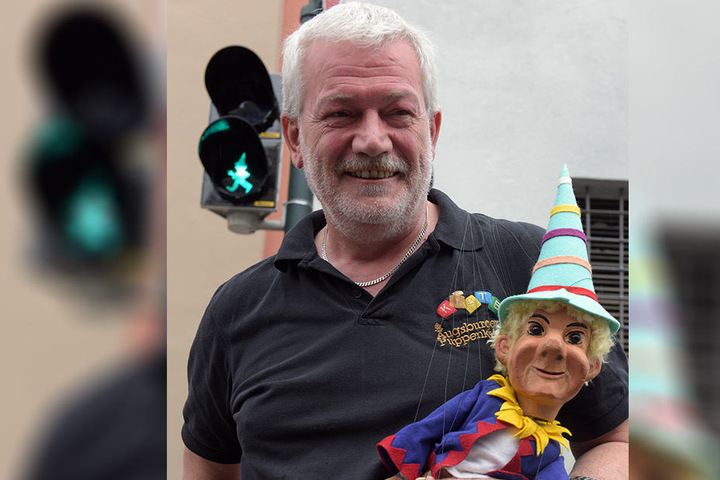 Der Leiter der Augsburger Puppenkiste, Klaus Marschall mit der Marionette Kasperl an einer Ampel.