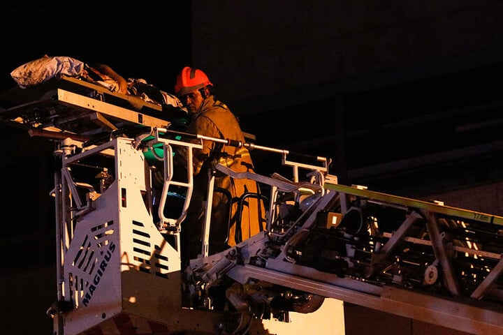 Ein Feuerwehrmann rettet eine Person mit einem Kran aus der Flammenhölle.