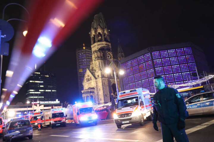 Polizisten und Rettungskräfte stehen vor der Gedächtniskirche in Berlin.