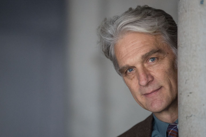 Der Schauspieler Walter Sittler im Theaterhaus neben einer Säule.