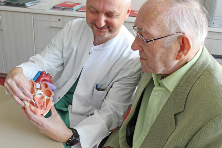 Oberarzt Marc Schönweiß erklärt Werner Milde (87), wo das kleine Wunderwerk eingesetzt wurde.