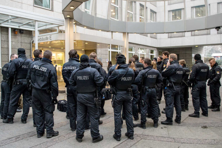 Eine Einsatzgruppe der Polizei steht am Verhandlungstag vor dem Gebäude E des Oberlandesgerichts in Frankfurt am Main.