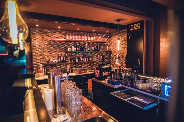 Die Bar ist gut bestückt und mit altmodisch gestalteten Leuchten dekoriert.