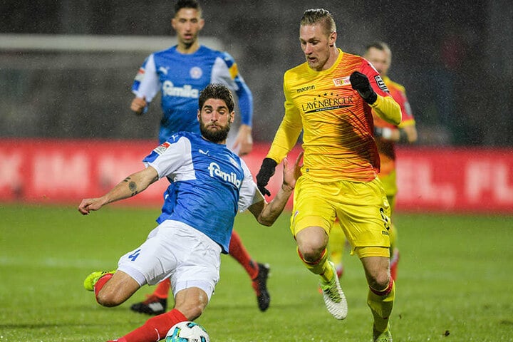 Kiels Niklas Hoheneder (l) und Berlins Sebastian Polter kämpfen um den Ball.