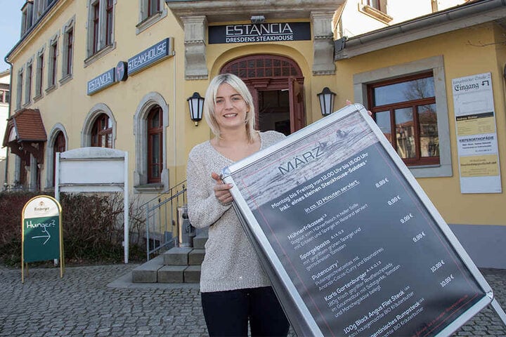 Chefin Alisa Zuber (27) platziert den Aufsteller für das März-Mittagsangebot vor ihrem neuen "Estancia"-Steakhaus in Klotzsche.