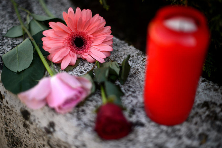 Blumen und ein Grablicht vor dem Haus.