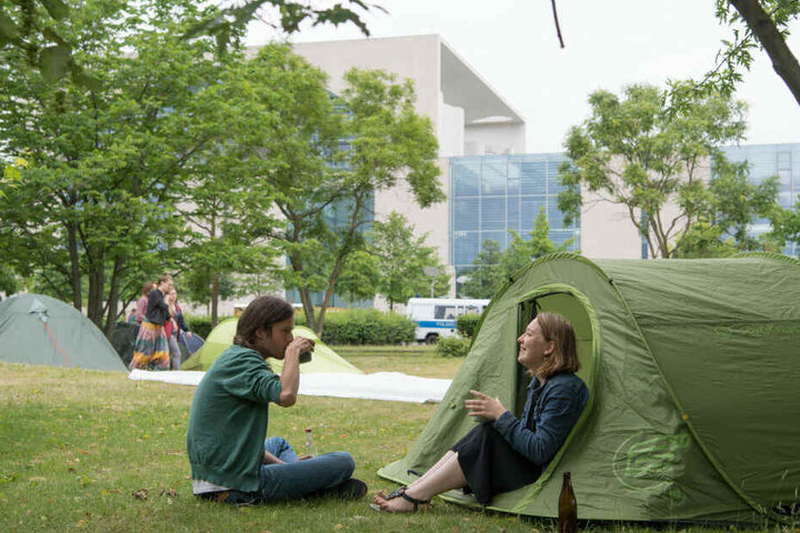 Teilnehmer der Demo sitzen an ihrem Zelt im We4Future-Camp.