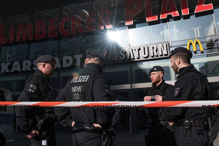 Polizisten stehen vor dem abgesperrte Einkaufszentrum.
