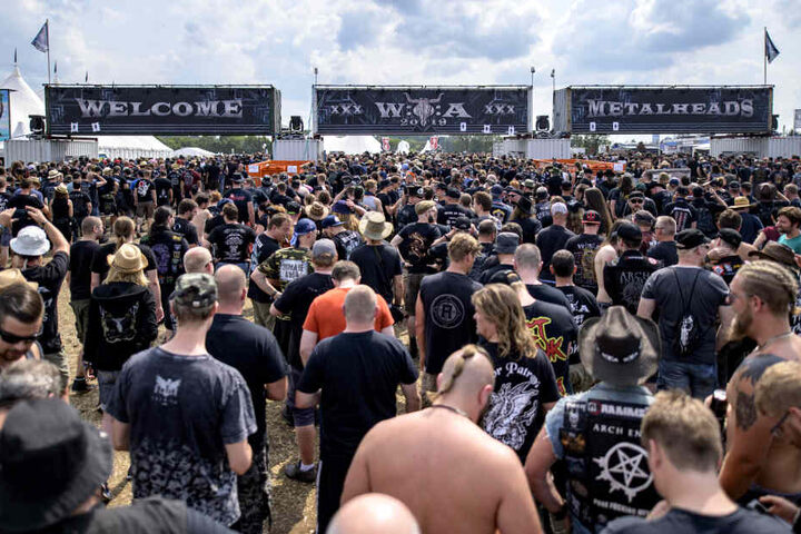Besucher des Wacken Open Air strömen durch die Eingänge des Festivals auf das Veranstaltungsgelände.