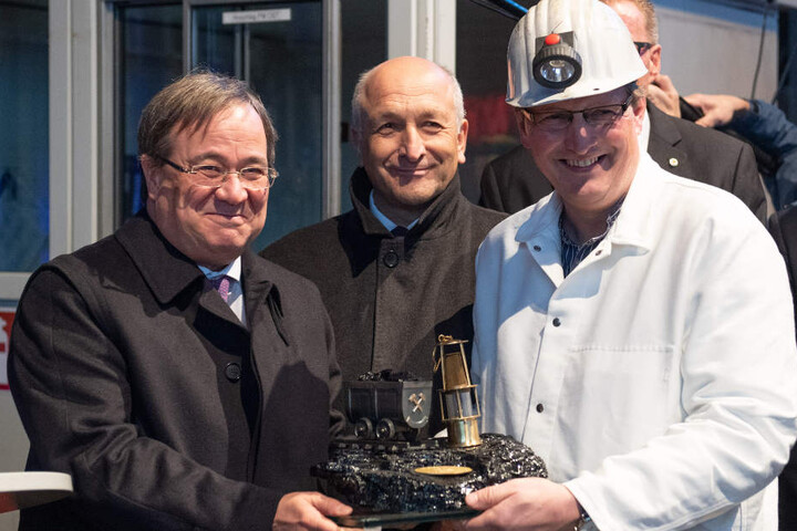 Armin Laschet (CDU) nimmt von einem Bergmann ein Stück Kohle als Geschenk im Empfang.