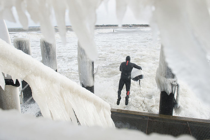 Mit Neoprenanzug wagt sich ein Surfer in die stürmische Ostsee.