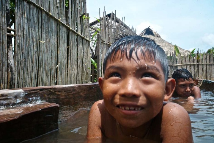 Kinder des Stammes der Kuna spielen im Wasser im Dorf Ustupu auf den San-Blas-Inseln