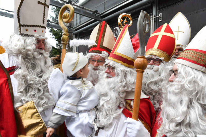 Sechs Nikoläuse stehen nach einem Gottesdienst vor der katholischen Kirche in Friedrichshafen-Jettenhausen.