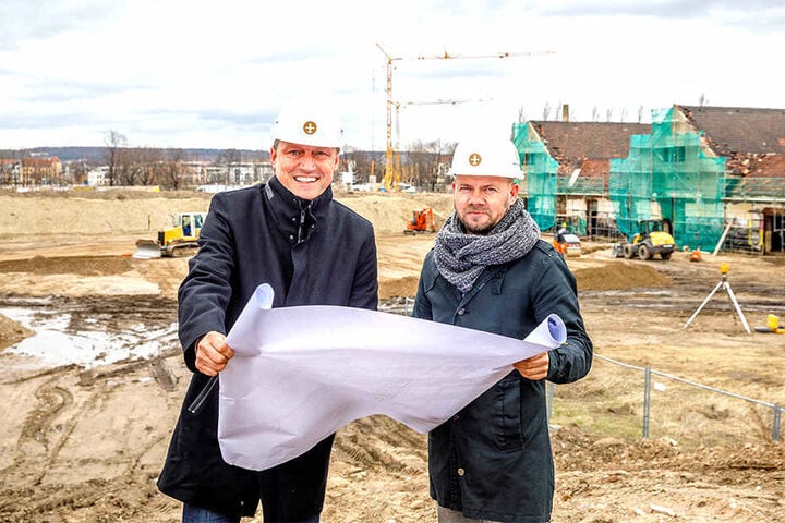 Mirco Meinel (47, l.) und sein Projektleiter Jörg Ullrich (48) schauen auf den Bauplan. Direkt hinter ihnen wird der "Ostra-Dome" entstehen. Rechts im Foto: die künftigen "Ostra-Studios".