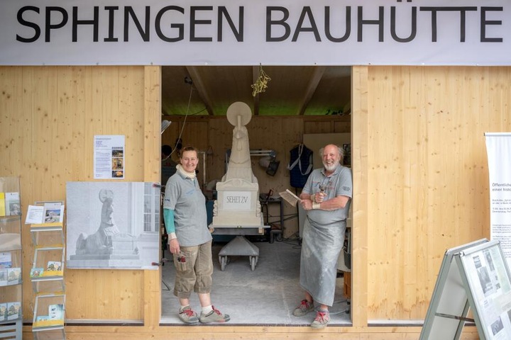 Vor der Sphingen-Bauhütte am Friedhof stehen die Steinmetzmeister Barbara Oppenrieder (l) und Wolfgang Gottschalk.