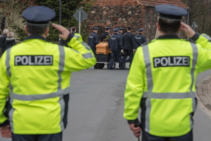 Zwei Polizisten salutieren bei der Beerdigung ihre von Jan G. im Einsatz getöteten Polizisten.