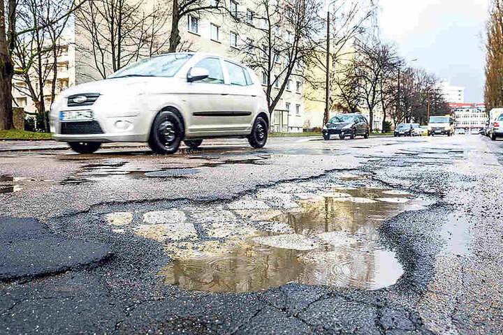 Die Enderstraße ist mit Schlaglöchern übersät. Autofahrer, Radler
und Busse müssen Slalom fahren.