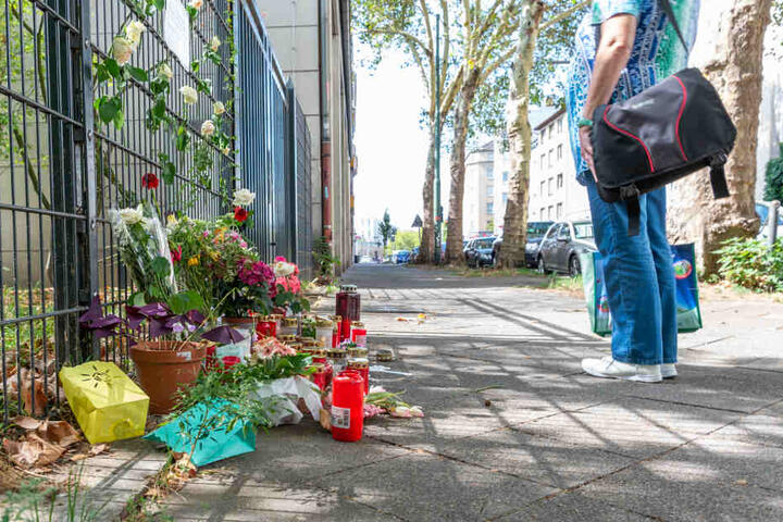 Am Tatort, an dem eine 36-jährige Frau erstochen wurde, liegen Blumen und Kerzen.