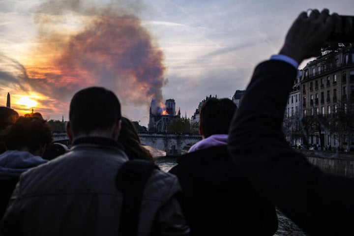 Zahlreiche Menschen sehen sich die Brennende Kathedrale Notre-Dame an.