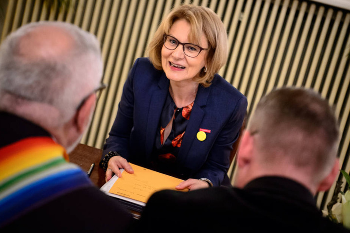 Die Leiterin des Standesamtes, Annette Bühler (Mitte), traut Integrationsbürgermeister Wolfgang Erichson (links) und seinen Ehemann Bertold Quast (rechts).