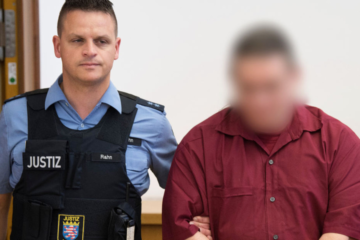 Der Angeklagte (r) wird zu einer Anklagebank im Landgericht Gießen geführt (Archivbild).
