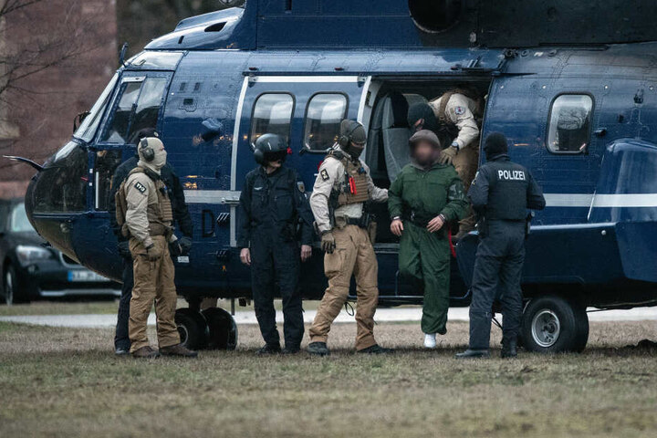 Beamte der Bundespolizei führen einen mutmaßliche Terrorverdächtigen aus einem Helikopter.