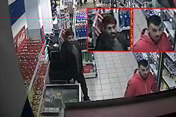 Beide Tatverdächtigen laufen durch einen Gang im Supermarkt.
