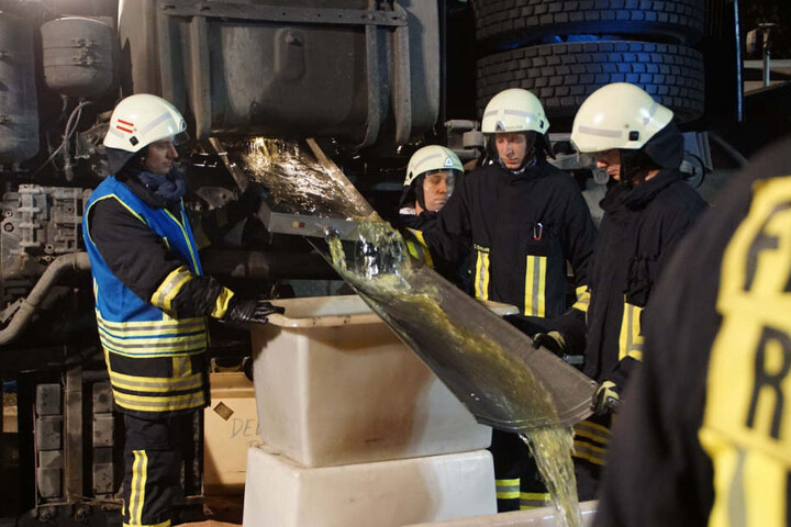 Feuerwehrleute füllen Diesel aus dem Tank des verunglückten Lastwagens um.