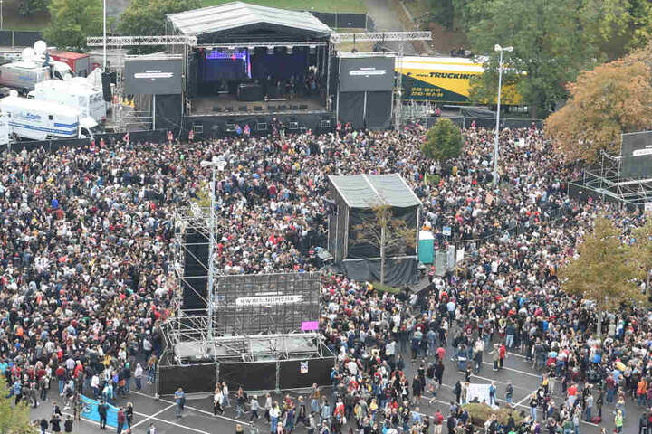 Zuschauer stehen vor dem Konzert unter dem Motto #wirsindmehr auf dem Parkplatz vor der Johanniskirche.