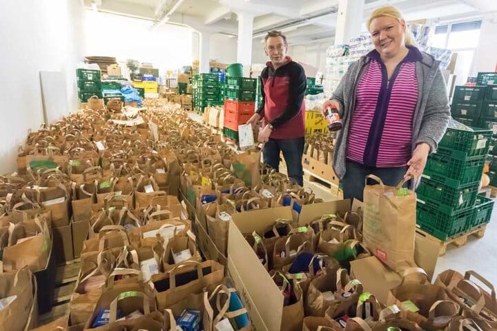Tafel-Mitarbeiter Elena Kerbel (37) und Dieter Böhme (61) packen die Weihnachtstüten.