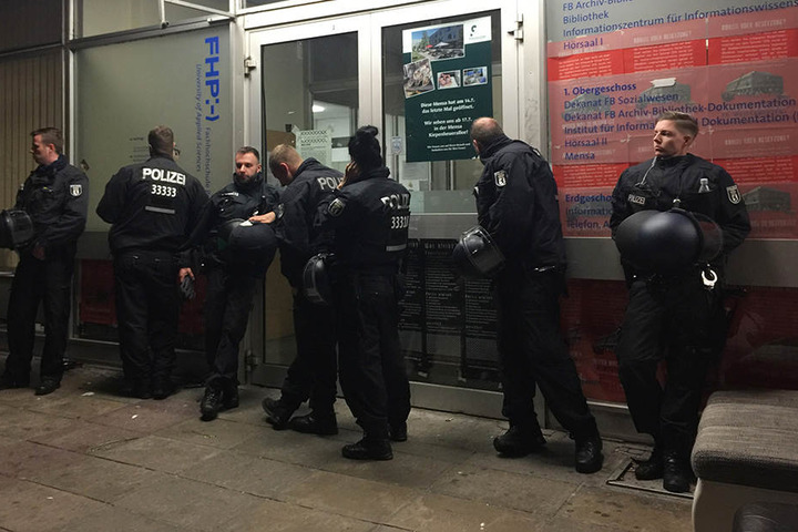Polizisten sichern den Haupteingang der geräumten Fachhochschule in Potsdam.