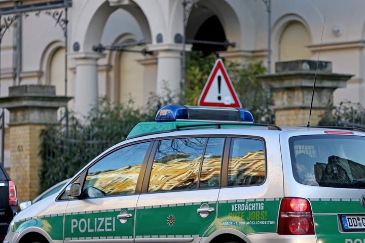Ein Polizeiwagen steht vor dem Haus des Justizministers. Die Beamten sichern Pflastersteine und Reste von Buttersäure-Stinkbomben.